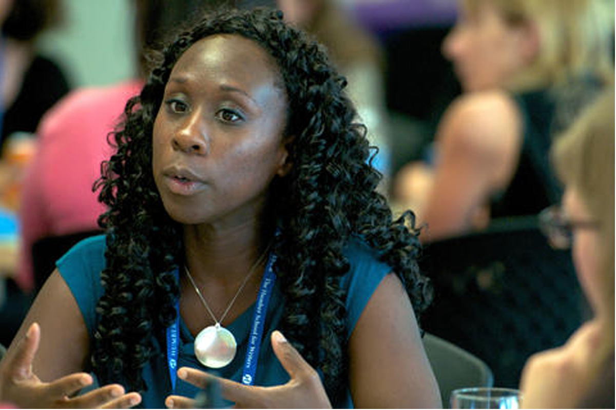 Black woman talking and gesturing at an event